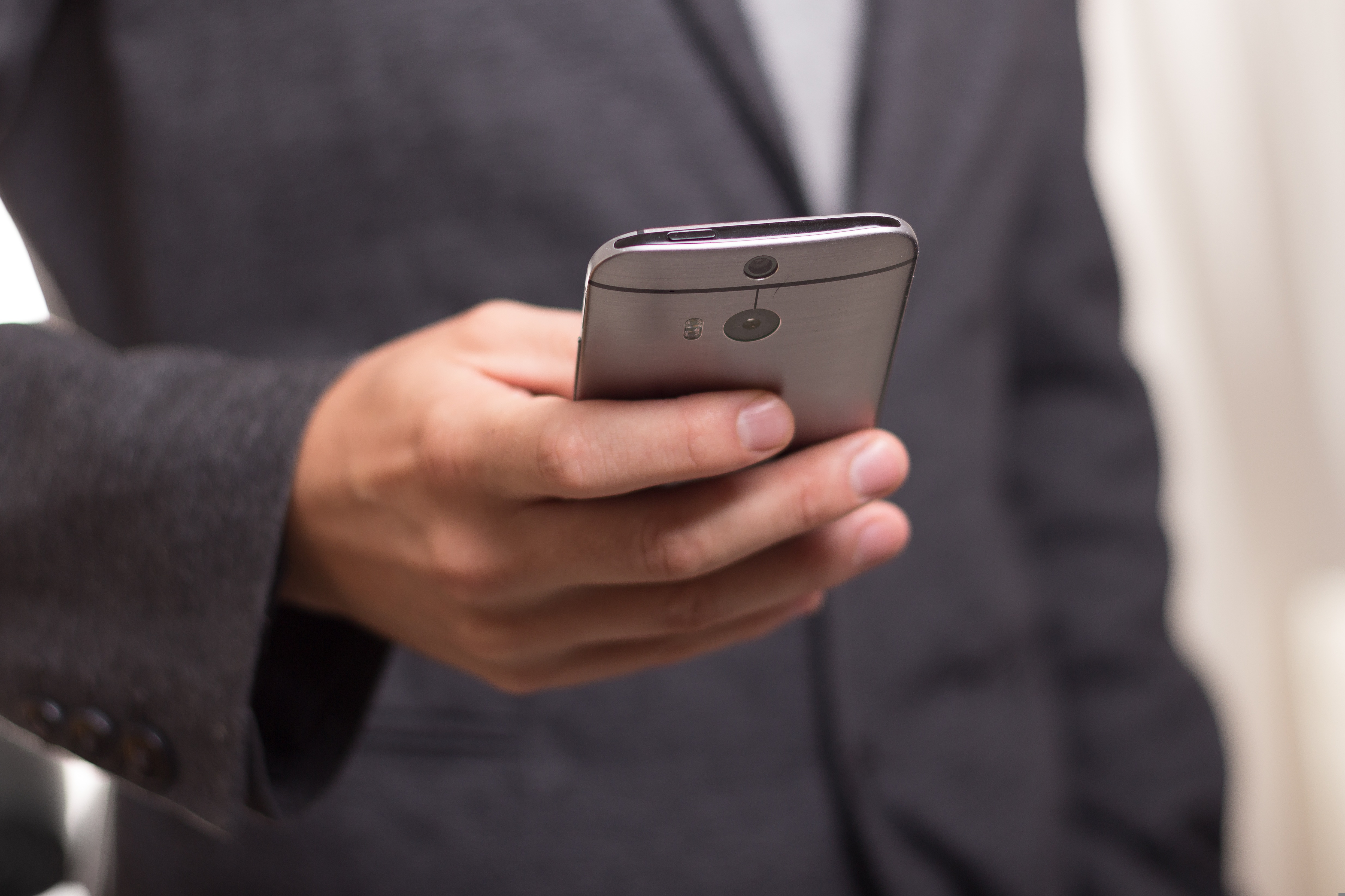 A cell phone. We can tell it is being held by a man in a suit.